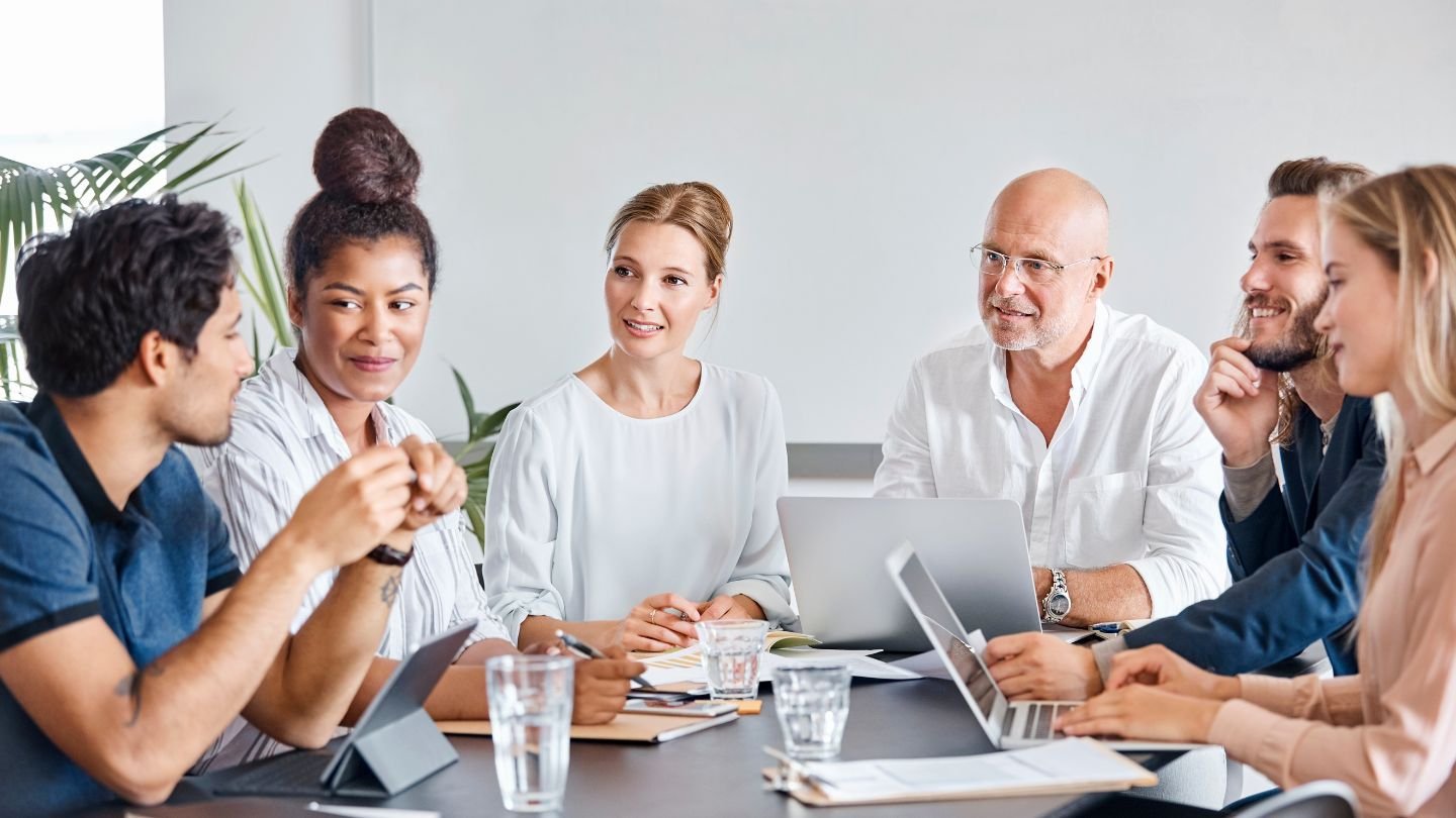 A family sitting together at a financial planning meeting, discussing estate planning and asset protection with a professional trustee.
